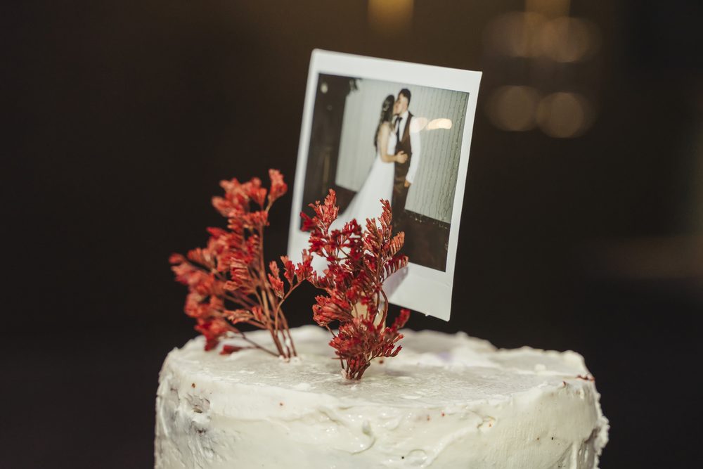 Fotografía polaroid de los novios sobre la tarta de boda