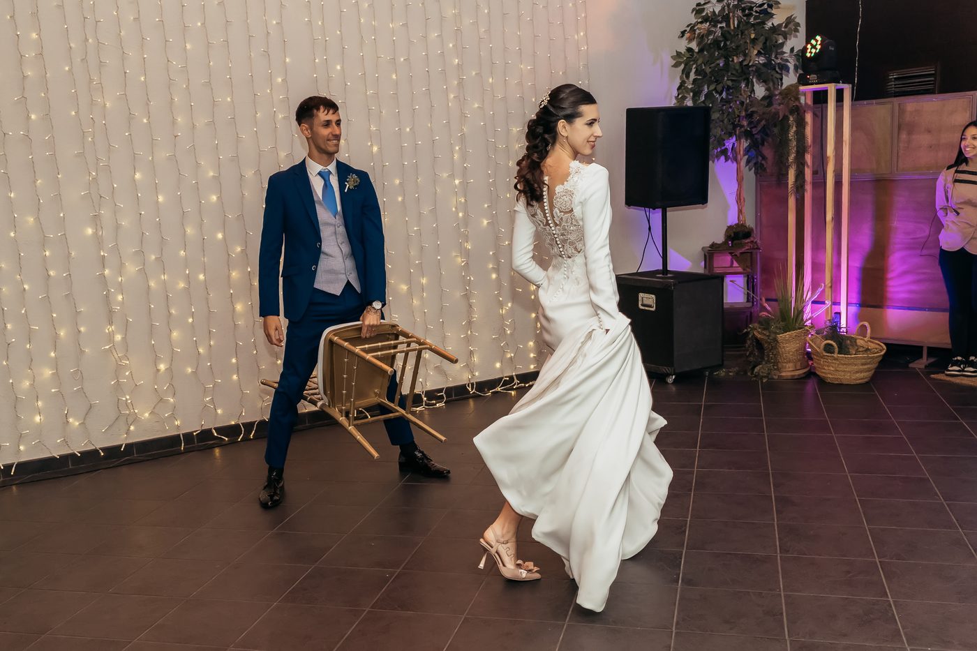 Novios caminando en movimiento entre una cortina de luces
